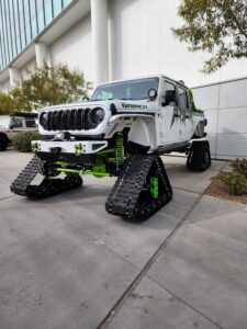 a white jeef rubicon sitting on triangular tracks